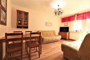 ein Wohnzimmer mit einem Tisch und einem Sofa in der Unterkunft HoliApart Żeromskiego 2 in Krynica Morska