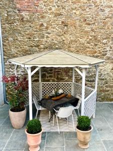 a gazebo with a table and chairs and plants at Villa Louisa in Saint Malo