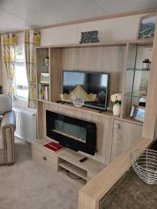 a living room with a tv and a flat screen at Hiker's Den, Brigham, Cockermouth, Cumbria in Cockermouth