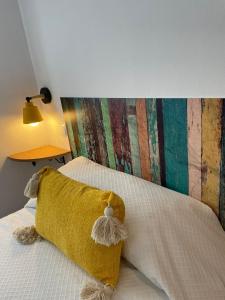 a bed with a yellow pillow on top of it at Sueños de Monfrague in Torrejón el Rubio