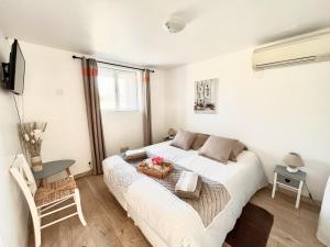 1 dormitorio con cama, mesa y TV en GITE AU BIEN AITRE en Beaumont-Pied-de-Boeuf