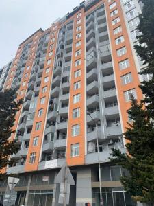 a tall apartment building with an orange at Kakha's Apartment in Batumi
