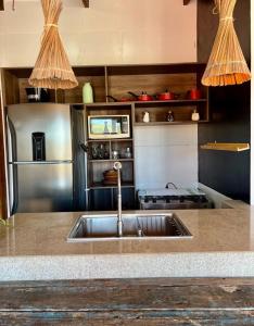 a kitchen with a sink and a stove at Apê do Fabiano Flats e lofts in Jericoacoara