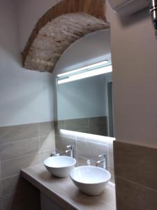 a bathroom with two sinks and a mirror at la stanza di Robi in Rio Marina