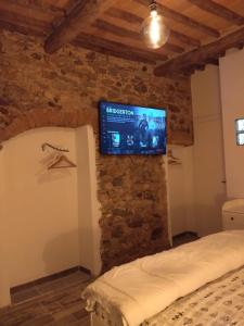 a bedroom with a tv on a brick wall at la stanza di Robi in Rio Marina