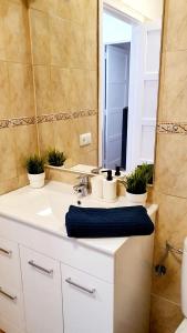 a bathroom with a white sink and a mirror at Beach House Apartment in Adeje