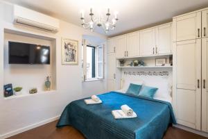 a bedroom with a blue bed with towels on it at Apartments Sounds of Dubrovnik in Dubrovnik