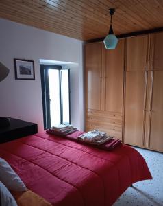- une chambre avec un grand lit rouge et une fenêtre dans l'établissement Nni Turiddu, à Cammarata