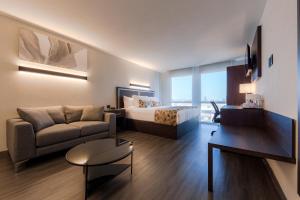 a hotel room with a bed and a couch at Sleep Inn Guadalajara Galerias in Guadalajara +70 photos