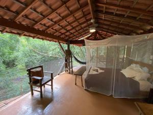 a room with a bed and a table and a chair at Cabana do Tarzan na Praia de Parati Mirim in Paraty