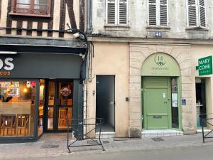 a building with a green door on a street at Appartement complet hyper centre in Auxerre