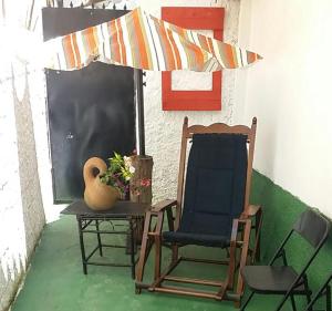 Hostel Limão Doce في نوفا فريبورغو: كرسي وطاولة مع مزهرية ومظلة