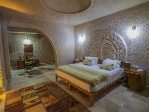 ein Schlafzimmer mit einem großen Bett in einem Zimmer in der Unterkunft Kalsedon Cave Suites in Nevşehir