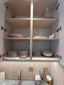 a cupboard with plates and dishes sitting in it at Golden MOOD City Apartment in Wrocław +48 photos