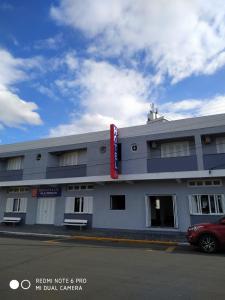 a building with a red car parked in front of it at Hotel Kruger in Tramandaí