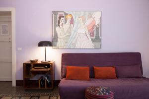un sofá púrpura en una sala de estar con una pintura en la pared en Tre Vie apARTment con terrazzo giardino pensile, en Catania