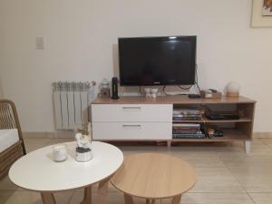 sala de estar con TV y mesa en Departamento Nuevo en Cipolletti en Cipolletti