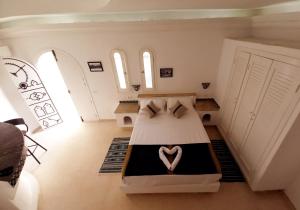 Un dormitorio con una cama con un corazón. en Dar ABDELKRIM en Al Ḩaddādah