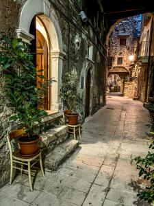 an alley with chairs and potted plants on a building at I Due Gradoni Stone House in Pacentro
