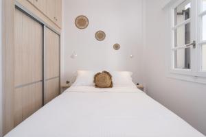 Red Beach Harmony suites Modestos في أكروتيري: غرفة نوم بسرير ابيض عليها سلة