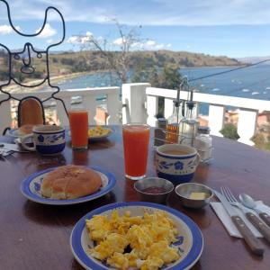 a table with plates of breakfast food on a balcony at Hotel La Cupula in Copacabana