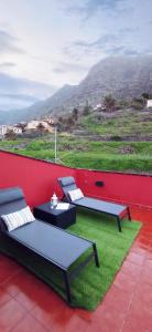 a patio with two couches and a table and grass at Casa Salitre in Hermigua