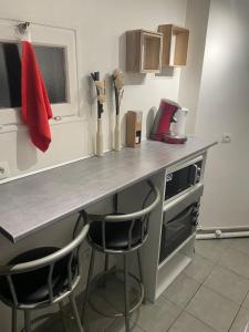 a kitchen with a counter and two stools at a counter top at Appartement complet hyper centre in Auxerre