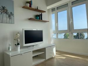 una sala de estar blanca con TV en un armario blanco en Apartamento Excelentes vistas a la Ria, Wifi y Parking, en San Vicente de la Barquera