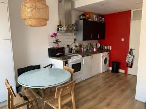 a kitchen with a table and a kitchen with red at London Spacious Apartment by DC London Rooms in London