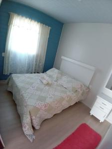 um pequeno quarto com uma cama e uma janela em Kitnet Namorados em Gramado