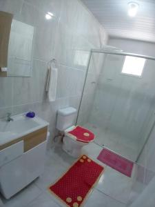 a bathroom with a shower and a toilet and a sink at Kitnet Namorados in Gramado