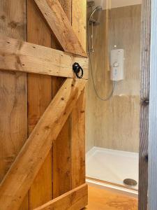 a bathroom with a shower in a wooden wall at Modern cabin with stunning views & private hot tub in Breakish