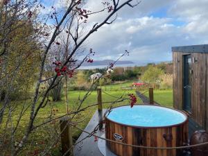 a wooden hot tub sitting in a yard at Modern cabin with stunning views & private hot tub in Breakish