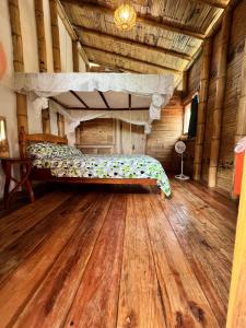 a bedroom with a bed and a wooden floor at hostal Monte Libano in Puerto López