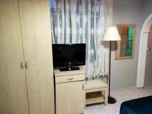 ein Zimmer mit einem Fernseher auf einer Kommode mit einer Lampe in der Unterkunft Side Erenler Hotel in Side