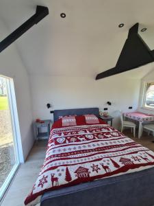 um quarto com uma cama com um cobertor vermelho e branco em 't Hûske em Venhorst