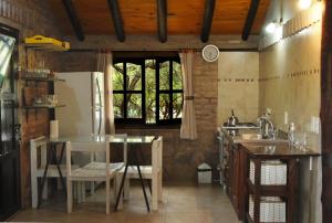 una cucina con tavolo e frigorifero di Cabanas en el Jardin Nativo a San Francisco del Monte de Oro
