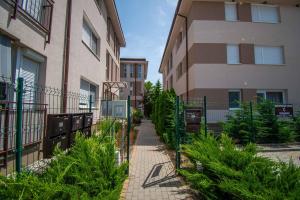 uma passagem entre dois edifícios de apartamentos com plantas em Mediterran Garden Apartman em Balatonboglár
