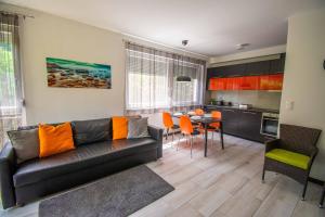 uma sala de estar com um sofá e uma mesa em Mediterran Garden Apartman em Balatonboglár