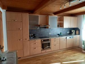 a large kitchen with wooden cabinets and stainless steel appliances at Vorderkreuzsaalgut Rettenwender Gertraud in Wagrain