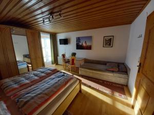 ein Schlafzimmer mit einem Bett und einem Sofa in der Unterkunft Vorderkreuzsaalgut Rettenwender Gertraud in Wagrain