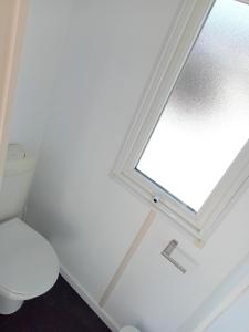 フレジュスにあるSpacieux Mobil-Home Fréjusのバスルーム(トイレ付)、窓が備わります。