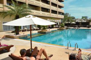 a group of people laying in chairs next to a swimming pool at View Talay Residence 6 Wongamat Sand Beach in North Pattaya