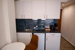 a kitchen with white cabinets and a sink at Acropolis of Athens from Ermou str in Athens