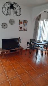 sala de estar con TV, mesa y sillas en Porta Reguengos - Apartamento moderno Alentejo central, en Reguengos de Monsaraz