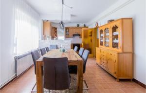 a dining room with a wooden table and chairs at Nice Home In Dakovo With Pool in Đakovo