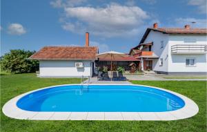 a large blue swimming pool in the yard of a house at Nice Home In Dakovo With Pool in Đakovo