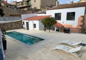 um pátio com 2 cadeiras e uma piscina em Costa Maresme, Barcelona ,Valentinos House & Pool em Vilassar de Dalt