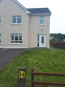a white house with a sign in front of it at NO 9 The Willows, Ballinamore, Entire home in Ballinamore