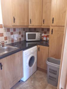 a kitchen with a washing machine and a microwave at NO 9 The Willows, Ballinamore, Entire home in Ballinamore